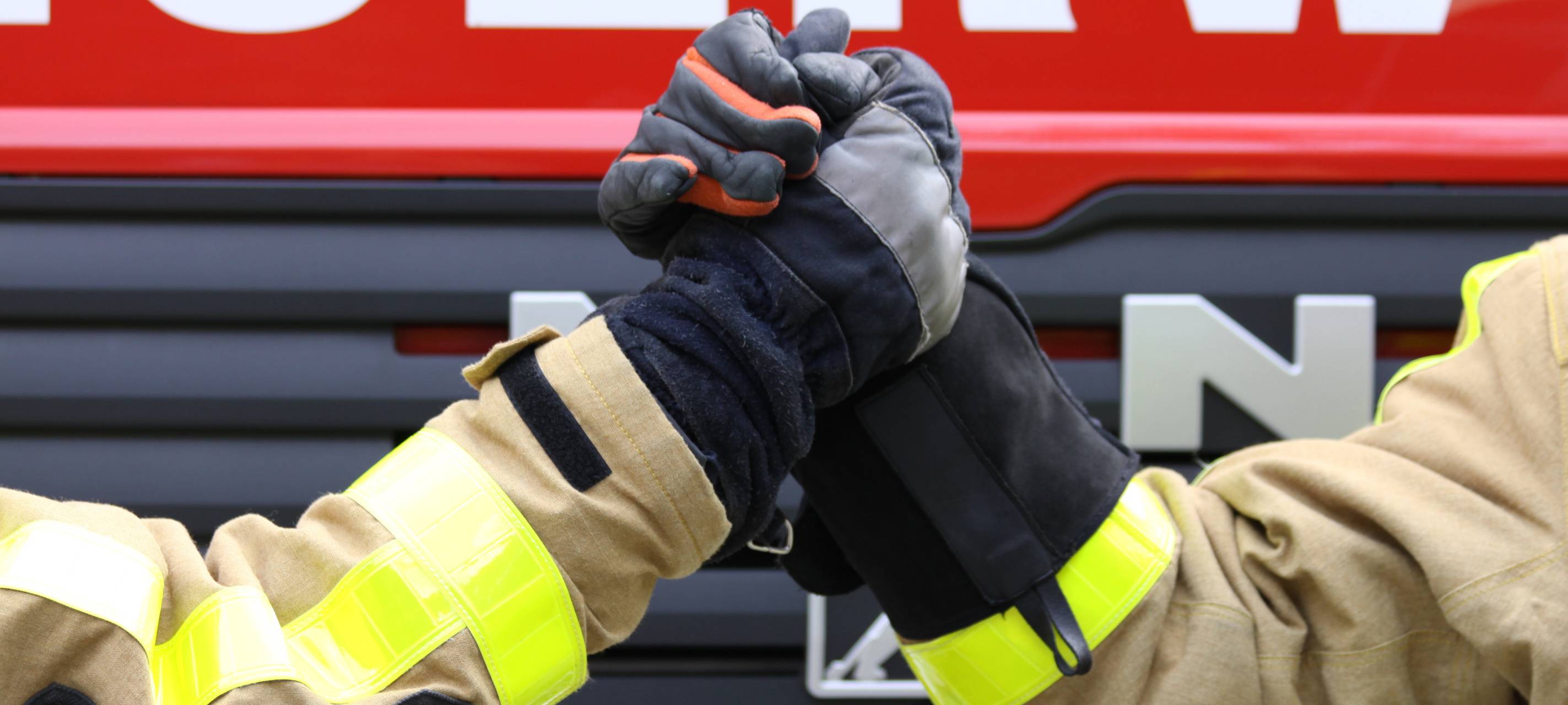Zwei Feuerwehrleute machen einen Handshake.