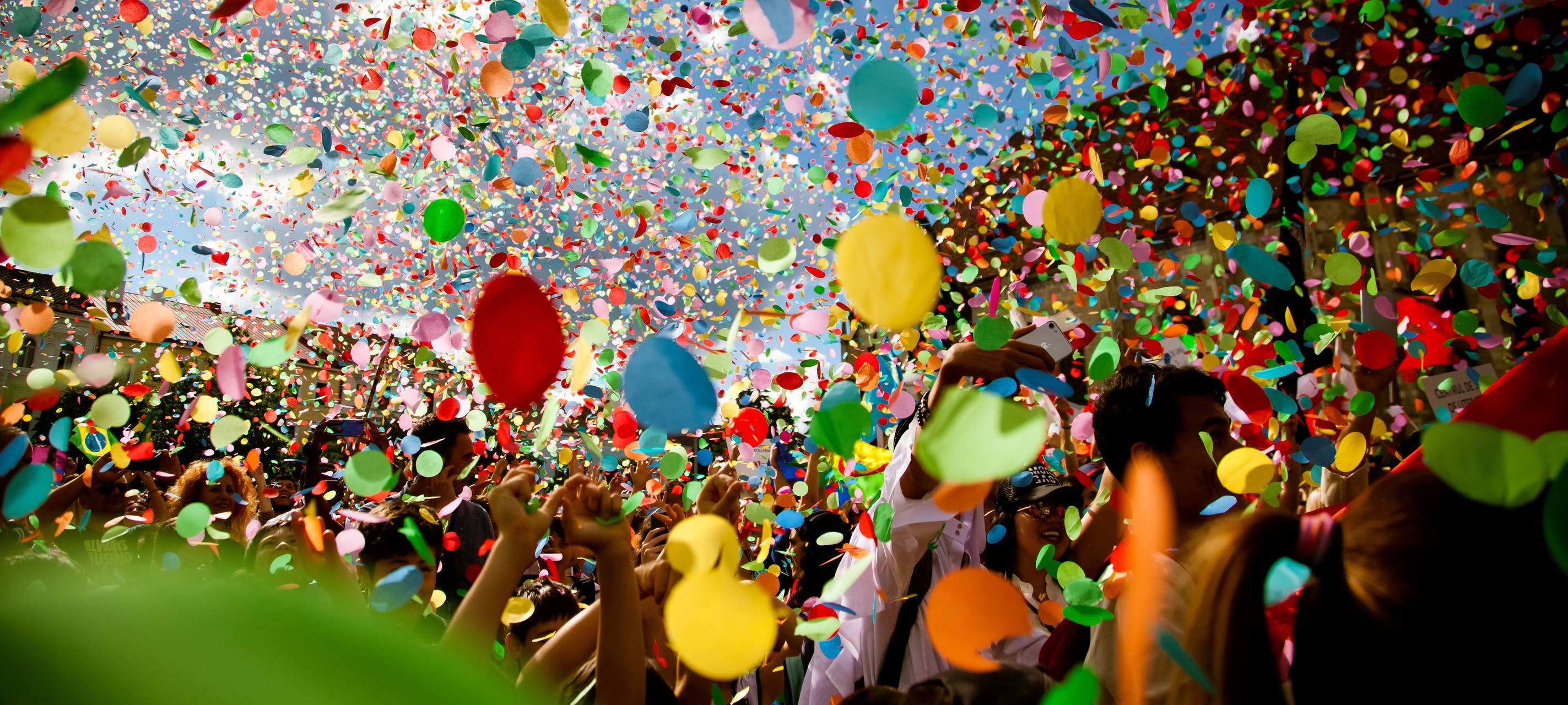 Konfetti-Regen geht auf eine Menschenmasse nieder.
