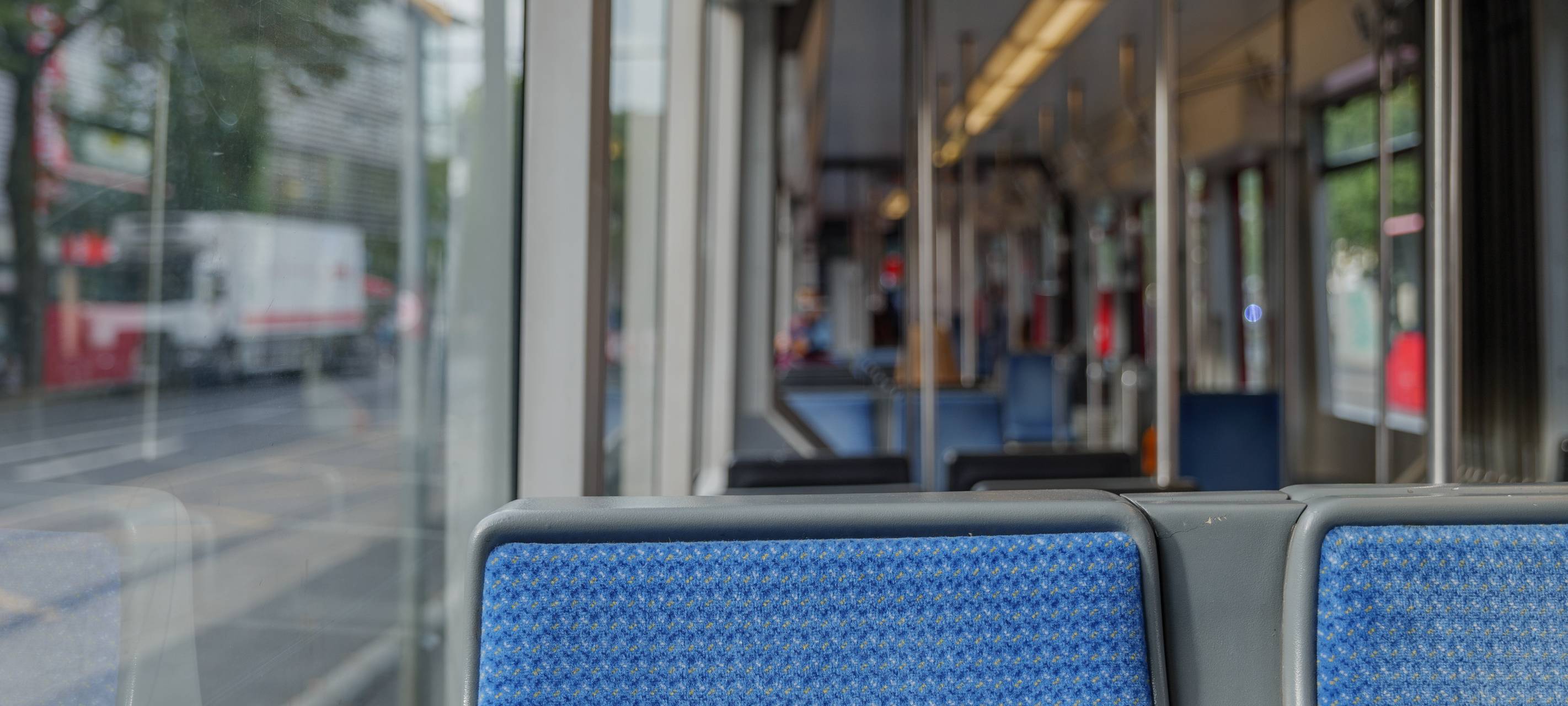 Innenansicht einer Straßenbahn der Rheinbahn. Die Sitze sind leer und blau.