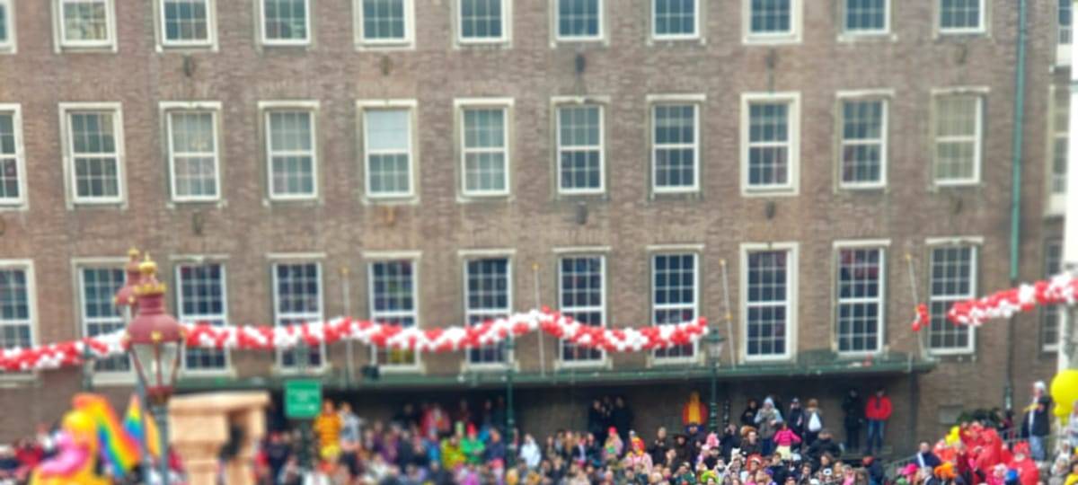Die KG Regenbogen zieht beim Rosenmontagszug in bunten Kostümen über den Marktplatz.