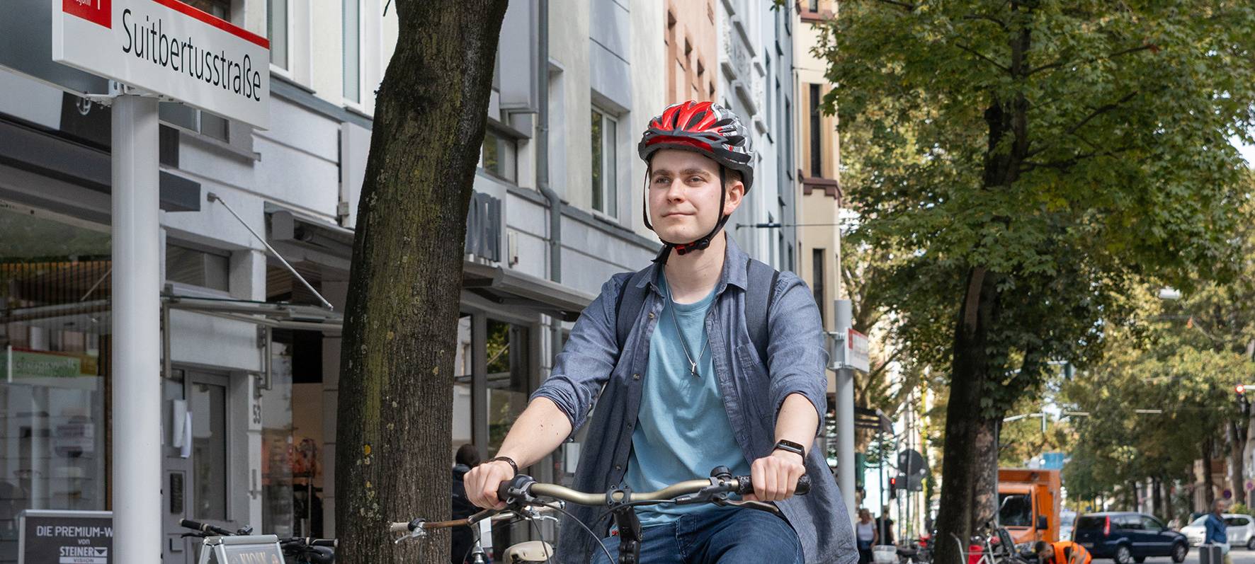 Radfahrer fährt an der neuen Haltestelle "Suitbertusstraße" vorbei.